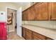 Laundry room with wood cabinets, granite countertop, and a red washer and dryer at 3677 N Hudson Dr, Florence, AZ 85132