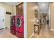 Laundry room with red appliances and access to the backyard at 3677 N Hudson Dr, Florence, AZ 85132