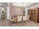 Rustic dining room with a brick feature wall and wood table at 41925 W Arvada Ln, Maricopa, AZ 85138