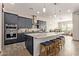 Spacious kitchen featuring dark cabinetry, granite island, and stainless steel appliances at 41925 W Arvada Ln, Maricopa, AZ 85138