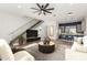 Modern living room featuring a ceiling fan, open staircase, and an adjacent kitchen with a breakfast bar at 4444 N 25Th St # 1, Phoenix, AZ 85016