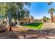 Backyard with grassy area, covered patio, and trees at 5448 W Shaw Butte Dr, Glendale, AZ 85304