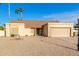 Tan house with a two-car garage and gravel driveway at 5448 W Shaw Butte Dr, Glendale, AZ 85304