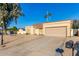 Tan house with a two-car garage and gravel driveway at 5448 W Shaw Butte Dr, Glendale, AZ 85304