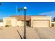 Tan house with a two-car garage and gravel driveway at 5448 W Shaw Butte Dr, Glendale, AZ 85304