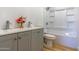 Bright bathroom featuring a double sink vanity, shower over tub and wood-look flooring at 5725 W Osborn Rd, Phoenix, AZ 85031