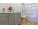 Bright bathroom featuring a double sink vanity, shower over tub and wood-look flooring at 5725 W Osborn Rd, Phoenix, AZ 85031