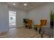 Bright living room with light wood floors, two yellow velvet chairs and view into adjacent room at 5725 W Osborn Rd, Phoenix, AZ 85031