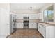 Well-lit kitchen featuring stainless steel appliances and white cabinets provides ample space at 60 W Beechnut Pl, Chandler, AZ 85248