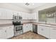 Bright kitchen offers stainless steel appliances, white cabinetry, and a large window above the sink at 60 W Beechnut Pl, Chandler, AZ 85248