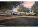 Backyard view of house at dusk with fire pit and trees at 6611 N 181St Ave, Waddell, AZ 85355