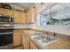 Clean kitchen featuring a double sink and wood cabinets at 6611 N 181St Ave, Waddell, AZ 85355