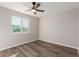 Well-lit bedroom with ceiling fan, wood-look flooring, and window views at 6936 W Berkeley Rd, Phoenix, AZ 85035