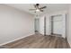 Spacious bedroom with ceiling fan, wood-look flooring, and large closet at 6936 W Berkeley Rd, Phoenix, AZ 85035