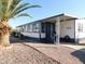 Single-wide mobile home with covered porch and landscaping at 8600 E Broadway Rd # 43, Mesa, AZ 85208