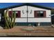 Cute single-wide mobile home with red shutters and desert landscaping at 8600 E Broadway Rd # 43, Mesa, AZ 85208