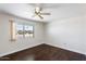 Bright bedroom with dark hardwood floors and a window at 9838 W Santa Fe Dr, Sun City, AZ 85351