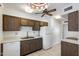 Kitchen with wood cabinets, white appliances, and a double sink at 9838 W Santa Fe Dr, Sun City, AZ 85351