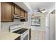 Kitchen with wood cabinets, stove and view to backyard at 9838 W Santa Fe Dr, Sun City, AZ 85351