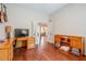 Bedroom with hardwood floors, a desk, a television, and double doors at 10814 W Palmeras Dr, Sun City, AZ 85373