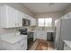 Modern kitchen with white cabinets, stainless steel appliances, and quartz countertops at 13558 W Saguaro Ln, Surprise, AZ 85374