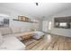 Spacious living room with L-shaped sofa, wood flooring, and views to the kitchen at 13558 W Saguaro Ln, Surprise, AZ 85374