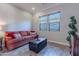 Cozy living room with a comfortable sofa and ottoman, offering natural light at 1401 E Sweet Citrus Dr, Queen Creek, AZ 85140