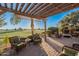 Relaxing patio with pergola, fire pit, wicker furniture, and golf course view at 1401 E Sweet Citrus Dr, Queen Creek, AZ 85140