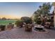 Evening view of a patio with fire pit and seating area overlooking a golf course at 1401 E Sweet Citrus Dr, Queen Creek, AZ 85140