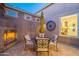 Cozy patio with fireplace, seating area, and views of the home's interior at 1401 E Sweet Citrus Dr, Queen Creek, AZ 85140