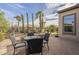 Beautiful backyard with a dining area and stone fountain, surrounded by lush greenery and palm trees at 1416 E Artemis Trl, Queen Creek, AZ 85140