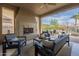 Inviting covered patio with a stone fireplace and ample seating, perfect for outdoor gatherings and relaxation at 1416 E Artemis Trl, Queen Creek, AZ 85140