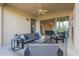 Comfortable covered patio with stylish furniture, ceiling fan, and sliding glass doors to the interior at 1416 E Artemis Trl, Queen Creek, AZ 85140