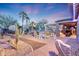 Evening view of a spacious backyard patio with fire pit and seating at 14426 W Becker Ln, Surprise, AZ 85379