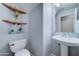 Clean bathroom with pedestal sink and floating shelves at 14877 N 145Th Dr, Surprise, AZ 85379