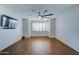 Bedroom with wood-look tile floors, large window, and mounted TV at 14877 N 145Th Dr, Surprise, AZ 85379