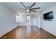 Spacious bedroom with wood-look floors, ceiling fan, and access to bathroom at 14877 N 145Th Dr, Surprise, AZ 85379
