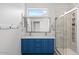 Bathroom with blue vanity, dual sinks, and glass shower at 1719 W Owens Way, Anthem, AZ 85086