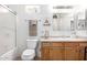 Clean bathroom with a shower/tub combo, vanity, and wood cabinets at 18706 W Arlington Rd, Buckeye, AZ 85326