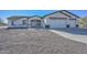 New construction home with a two-car garage and gravel landscaping at 20823 W Rainbow Trl, Buckeye, AZ 85326