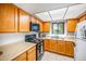 A functional kitchen with wood cabinets, laminate counters, and standard appliances for convenient meal preparation at 2315 W Union Hills Dr # 115, Phoenix, AZ 85027