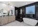 Luxurious bathroom featuring black marble and a soaking tub at 2330 N 28Th Pl, Phoenix, AZ 85008