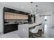 Sleek kitchen with island, contrasting wood and black cabinets, and modern lighting fixtures at 2330 N 28Th Pl, Phoenix, AZ 85008