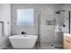 Elegant bathroom with marble shower, soaking tub, and modern fixtures at 2336 N 28Th Pl, Phoenix, AZ 85008