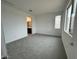 Neutral bedroom featuring a large window, grey carpet and a view of a bathroom at 25209 W Wayland Dr, Buckeye, AZ 85326