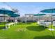Outdoor entertainment area with turf, umbrellas, and games at 3282 E Palo Verde Dr, Paradise Valley, AZ 85253
