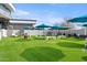 Outdoor entertainment area with turf, umbrellas, and games at 3282 E Palo Verde Dr, Paradise Valley, AZ 85253