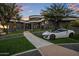 Curved modern home with landscaped grounds and a white car parked in the driveway at 3282 E Palo Verde Dr, Paradise Valley, AZ 85253