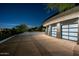 Modern three-car garage with glass panel doors and a large patio area at 3282 E Palo Verde Dr, Paradise Valley, AZ 85253