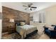 Cozy bedroom with wood-look accent wall, ceiling fan, and comfortable seating area at 33286 N 71St St, Scottsdale, AZ 85266